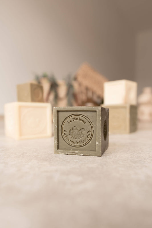 Square soap bar with 'La Marmite' branding on a textured surface.