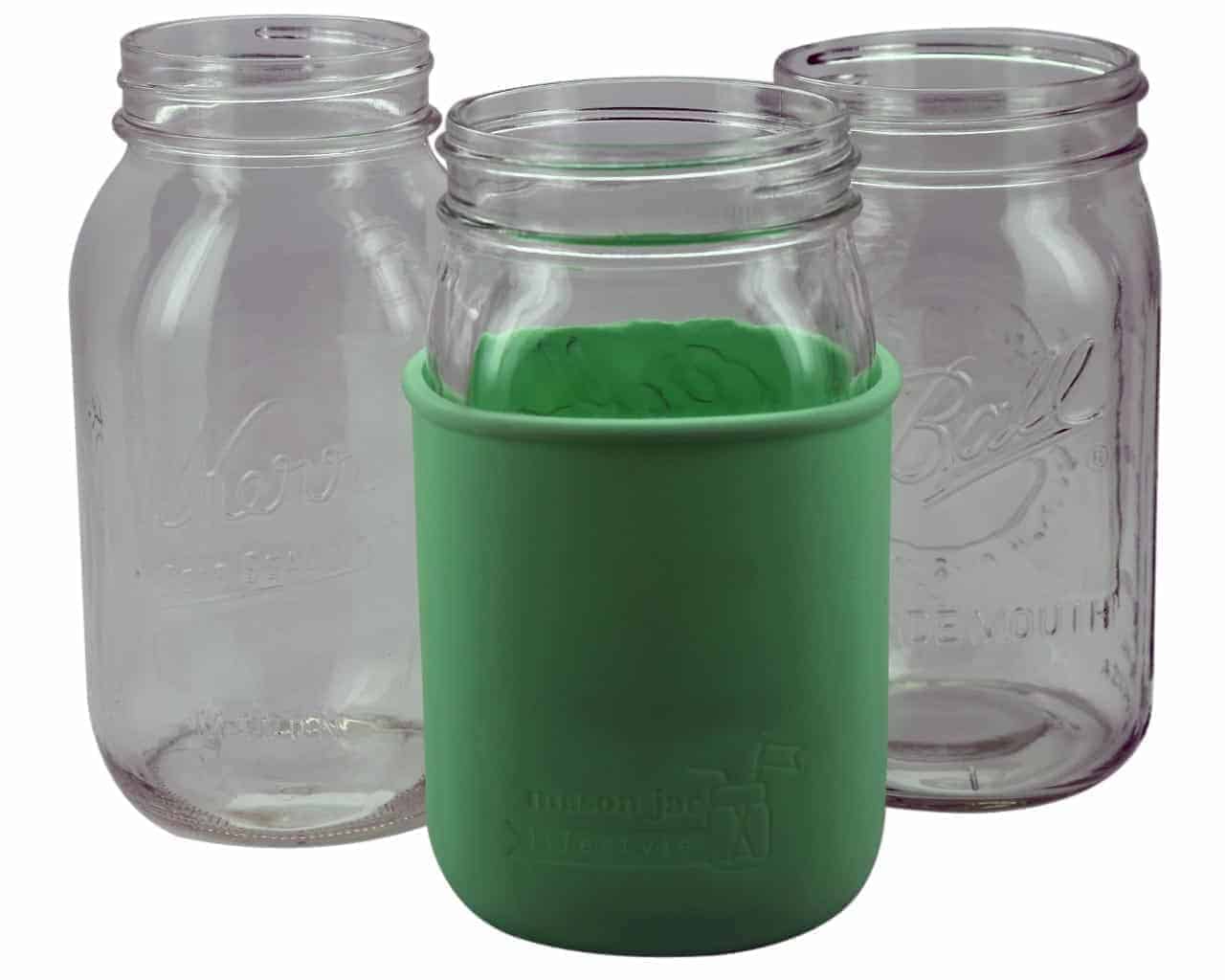 Clear glass jars with a green sleeve on a white background