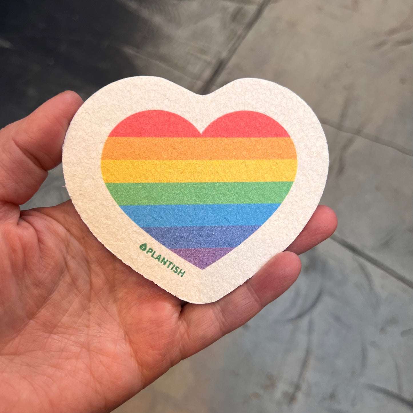 hand holding sponge: heart rainbow pattern
