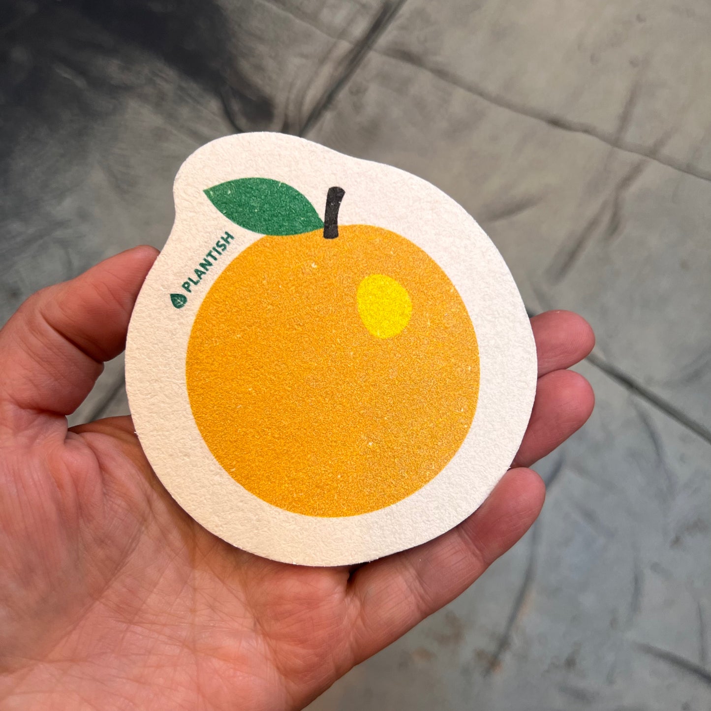 hand holding sponge: orange pattern