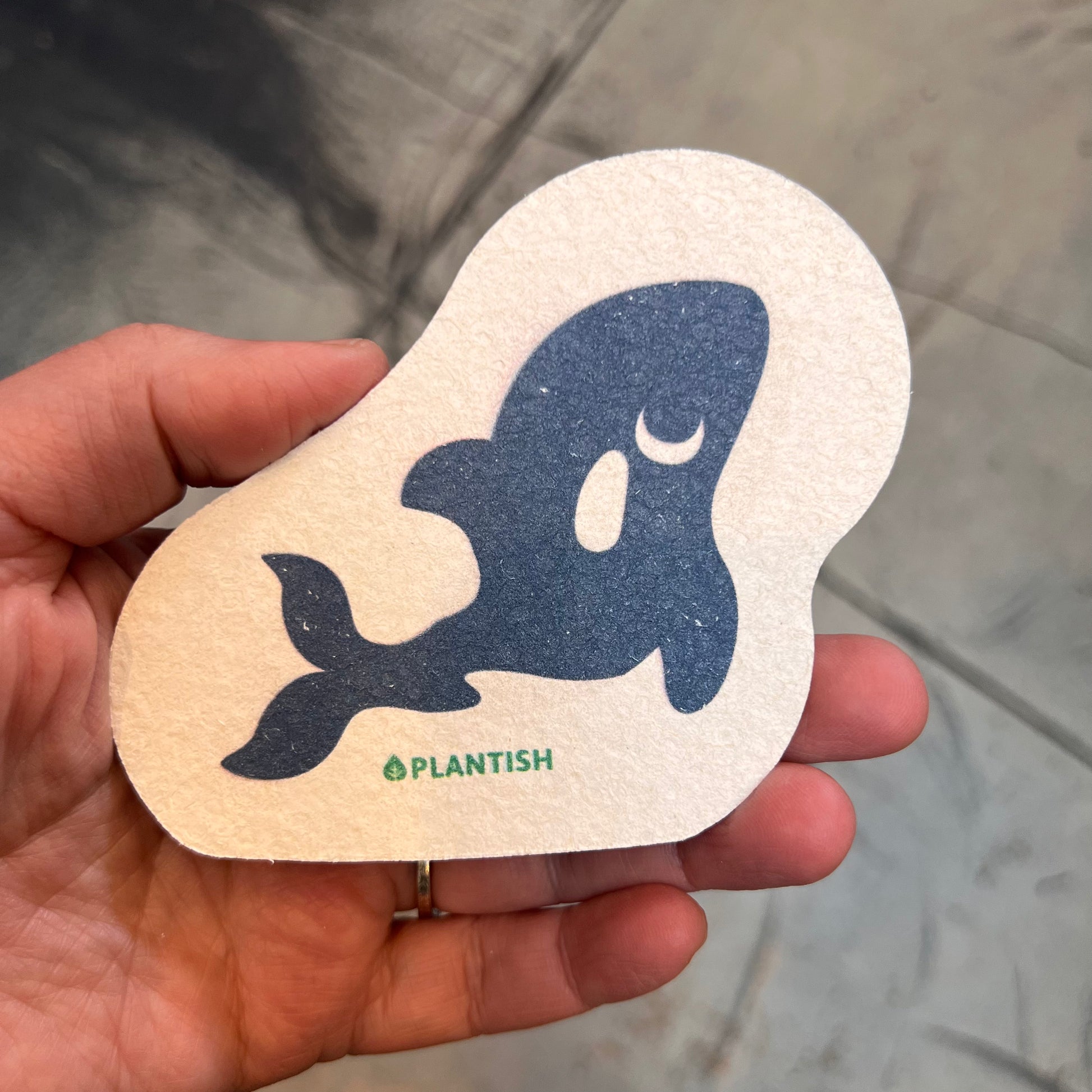 hand holding sponge: dolphin pattern