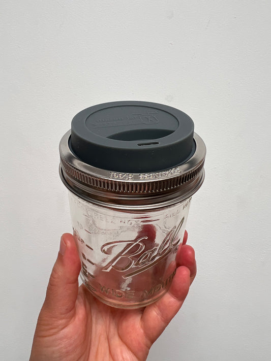 Wide mouth mason jar with gray silicone lid and metal band.