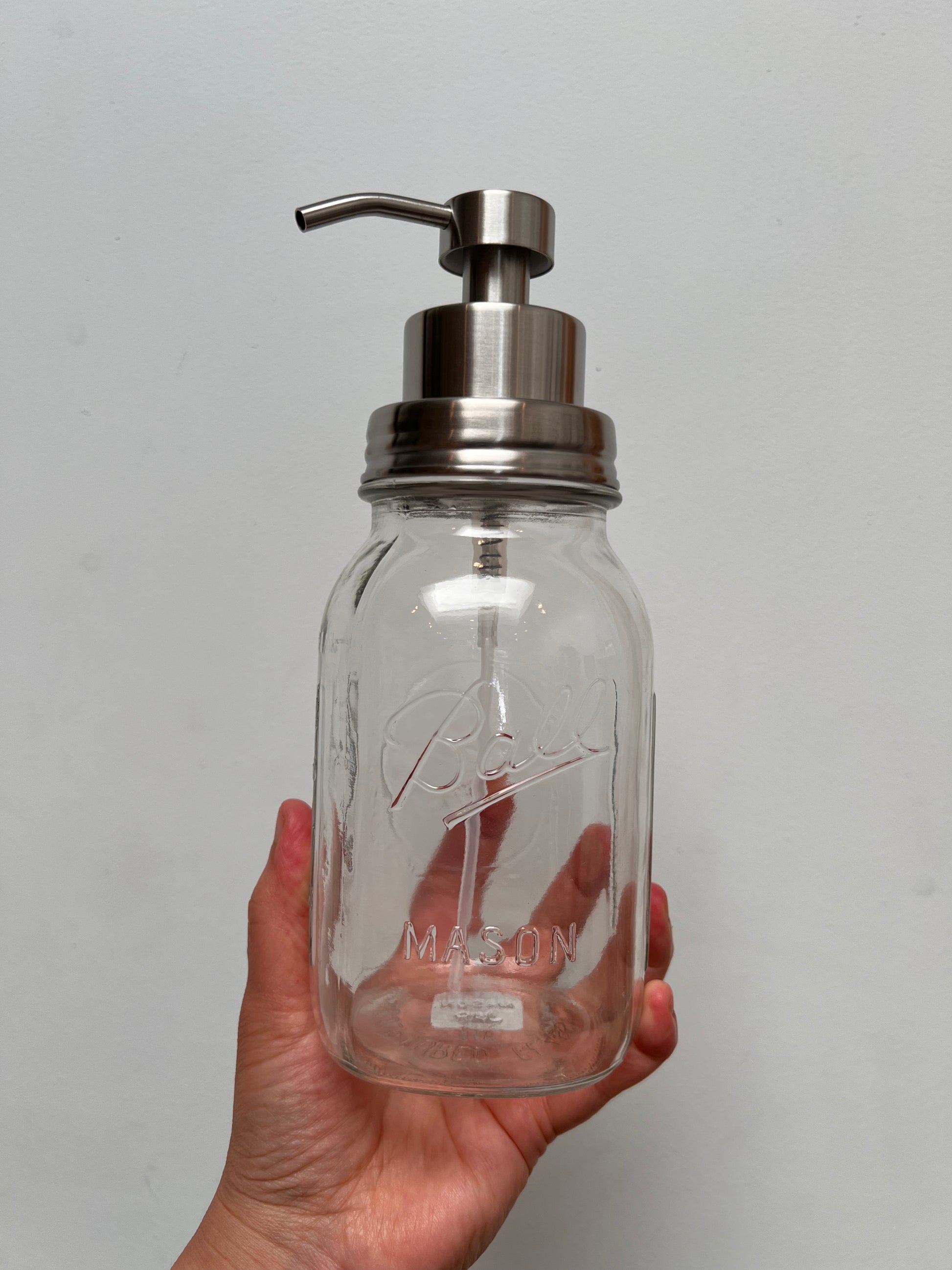 Hand holding quart mason jar with stainless steel foaming top