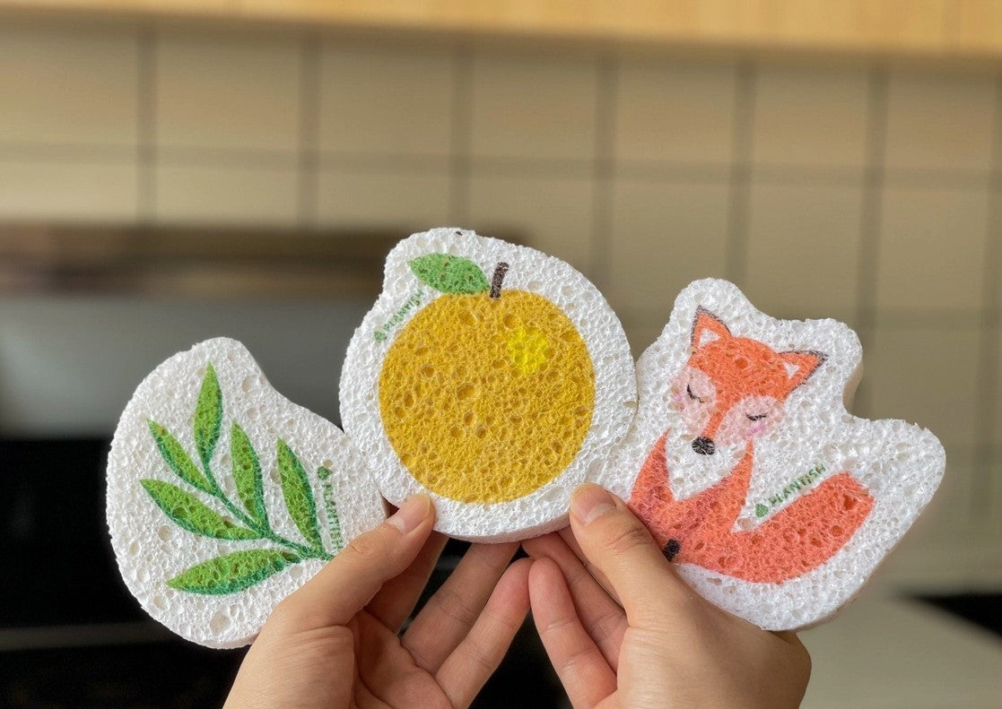 Hands holding 3 sponges, left to right, leaf pattern, orange pattern, fox pattern