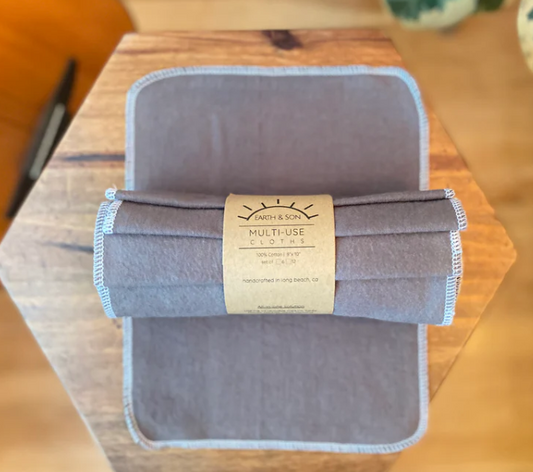 Folded gray multi-use cloth with a label on a wooden surface