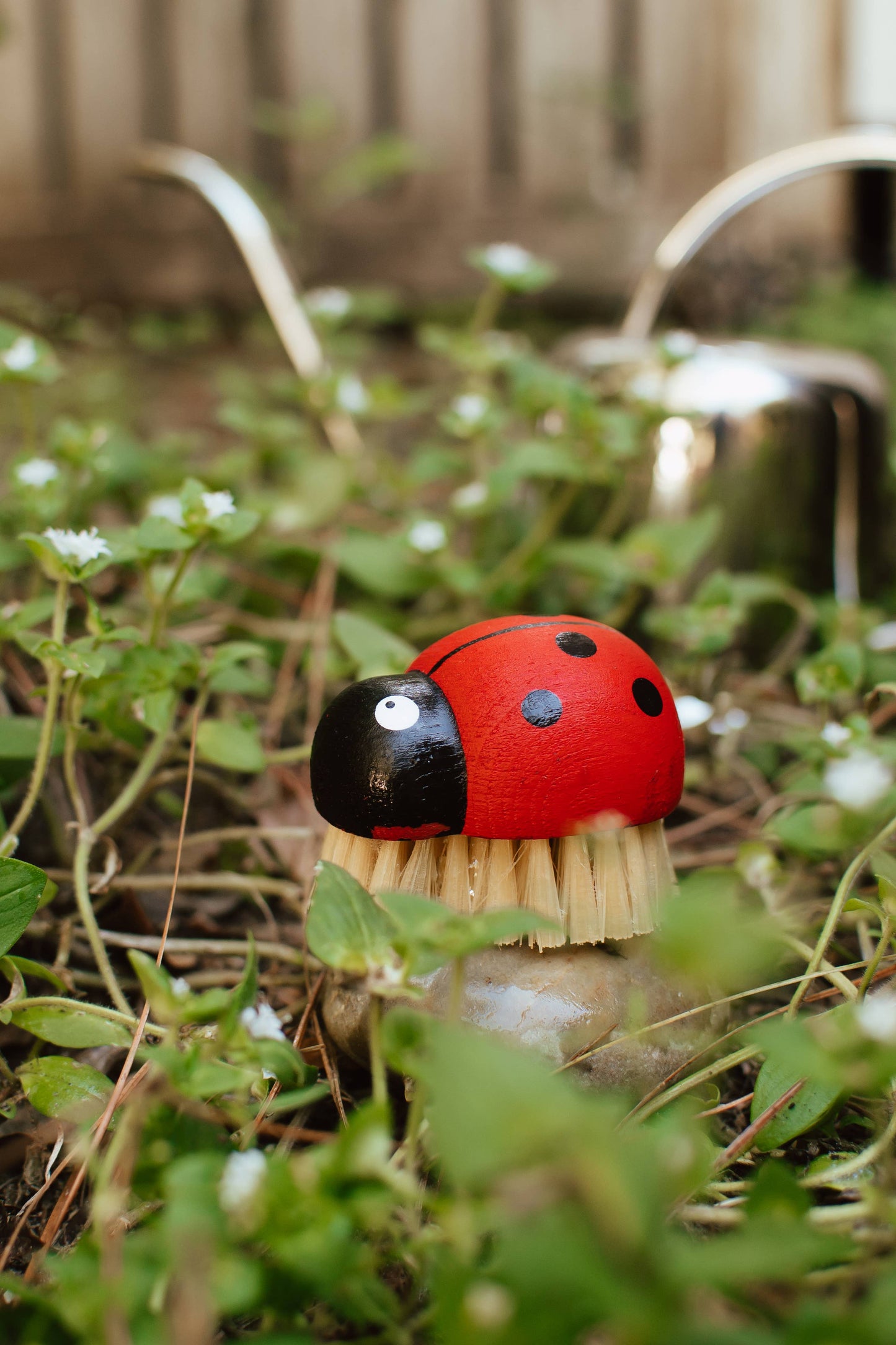 Garden tool with ladybug design in a natural setting