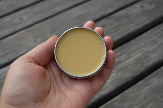 Fat and the Moon - All Salve metal tin with lid off showing the salve which is a light yellow color