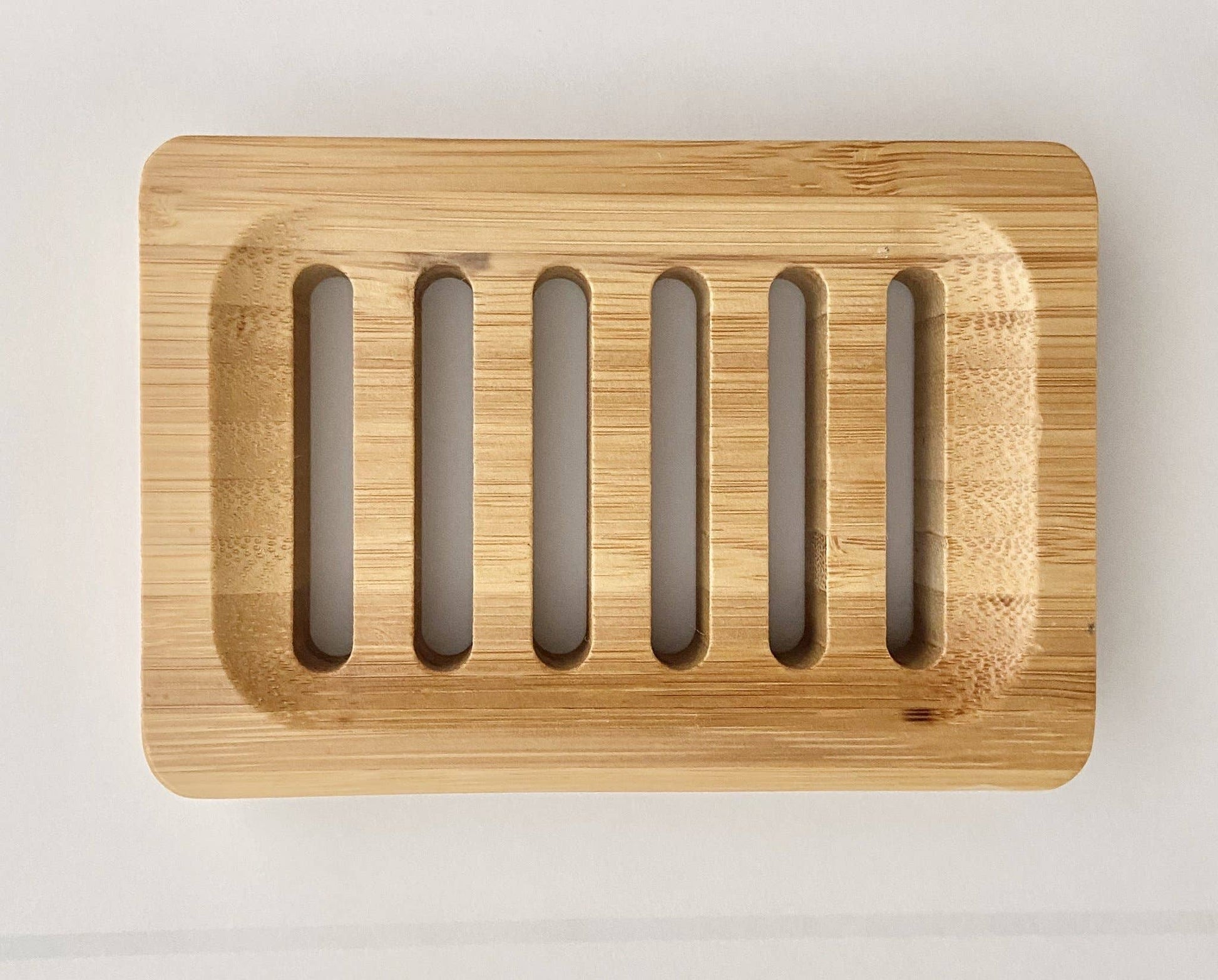 A large rectangular bamboo soap dish with multiple slots for soap bars.