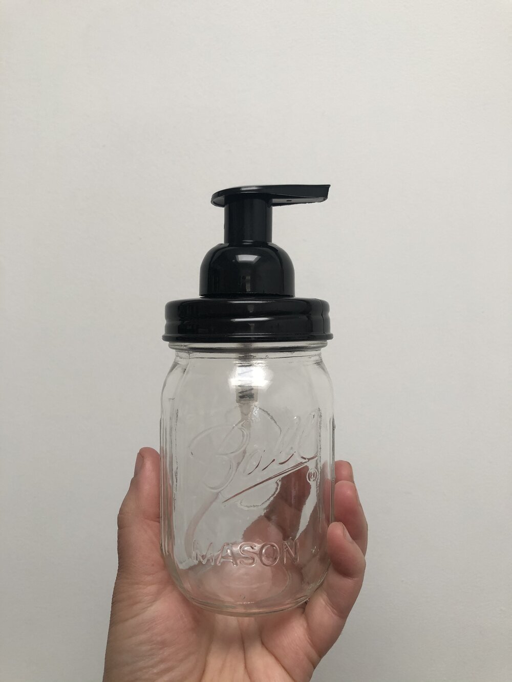 A Mason jar with a black foaming pump top and a regular mouth.