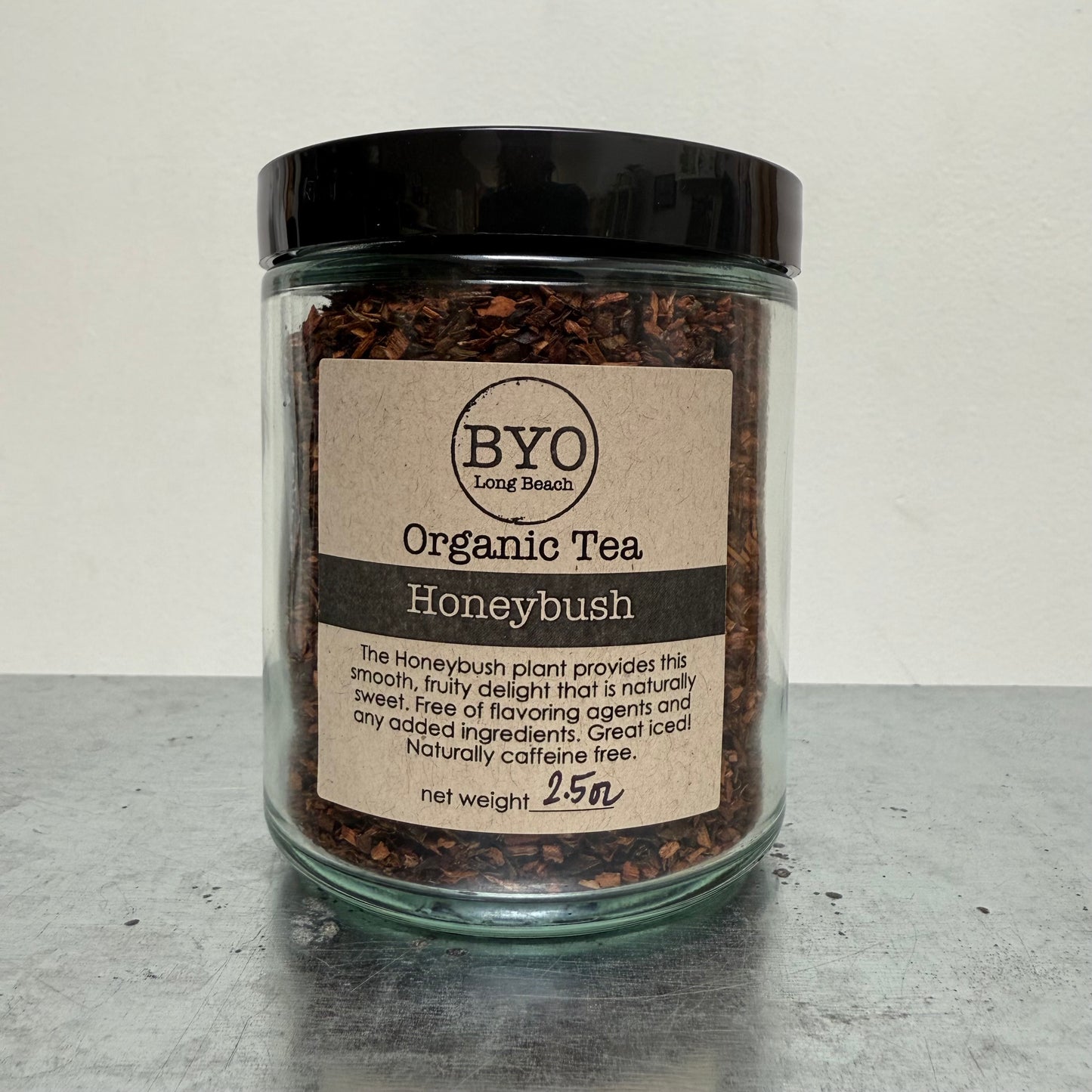 Jar of organic honeybush tea with a label on a gray surface