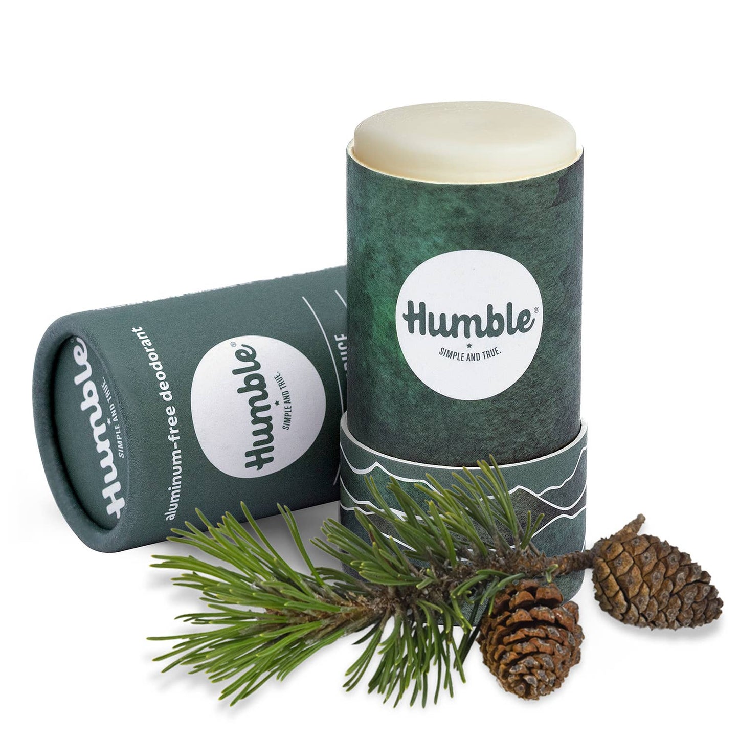 Two 'humble' aluminum-free deodorant sticks with a branch and pine cones on a white background