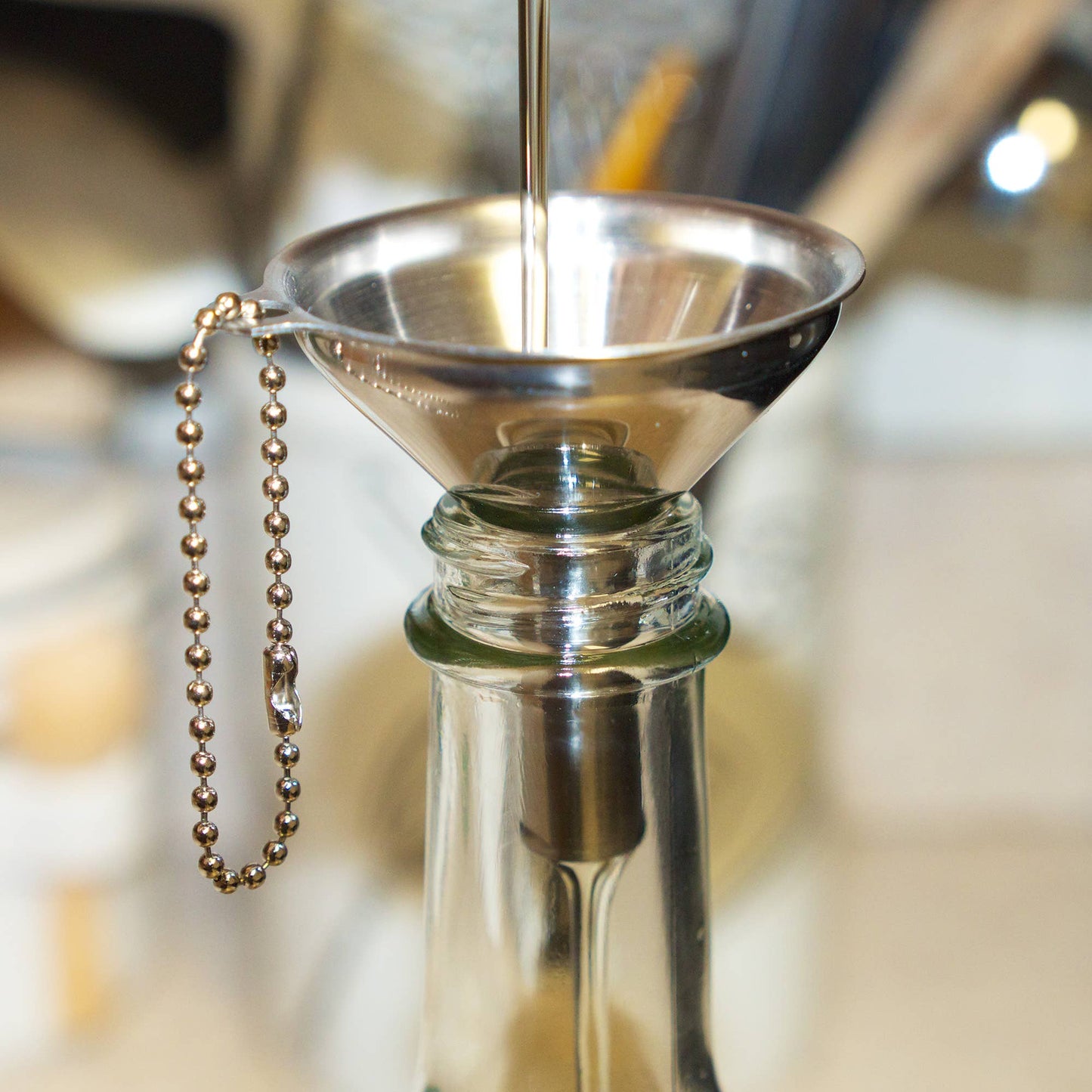 Metallic funnel attached to a bottle with a blurred background