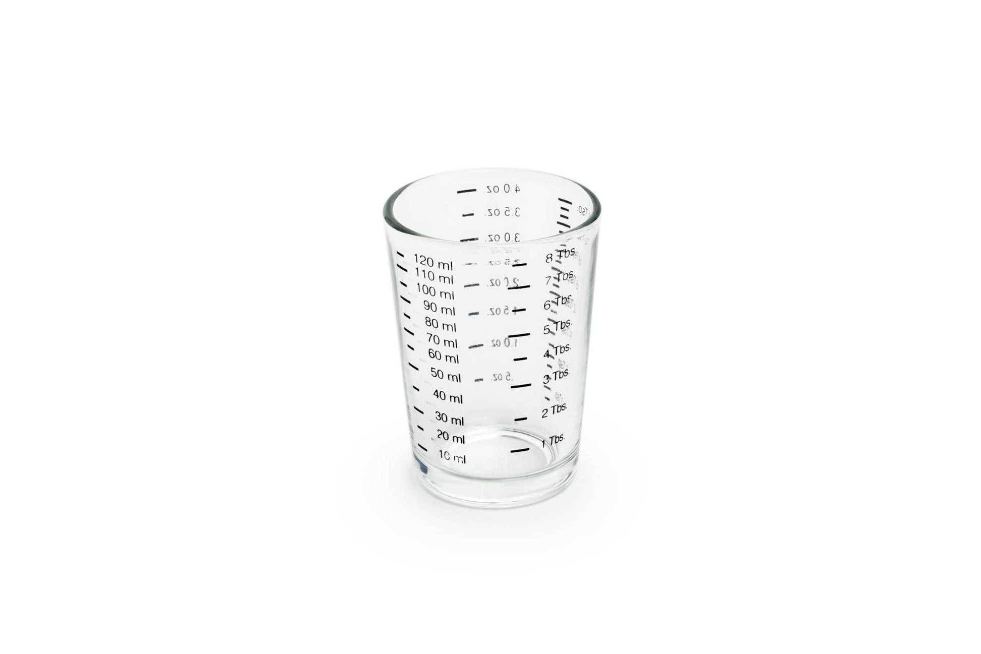 Clear glass measuring cup with measurements on a white background