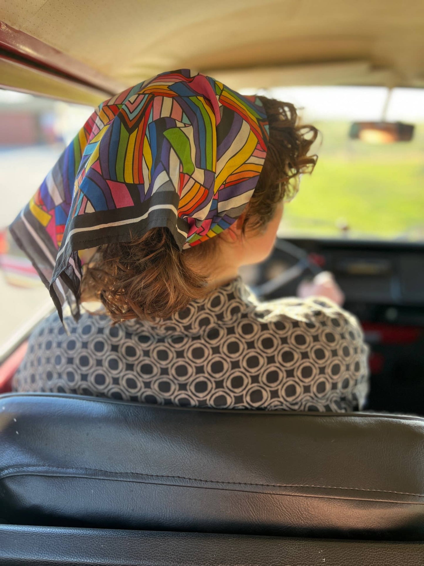 Person with a colorful headscarf sitting in a car
