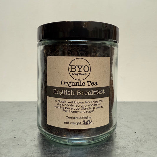 Jar of organic English Breakfast tea with a label on a gray surface
