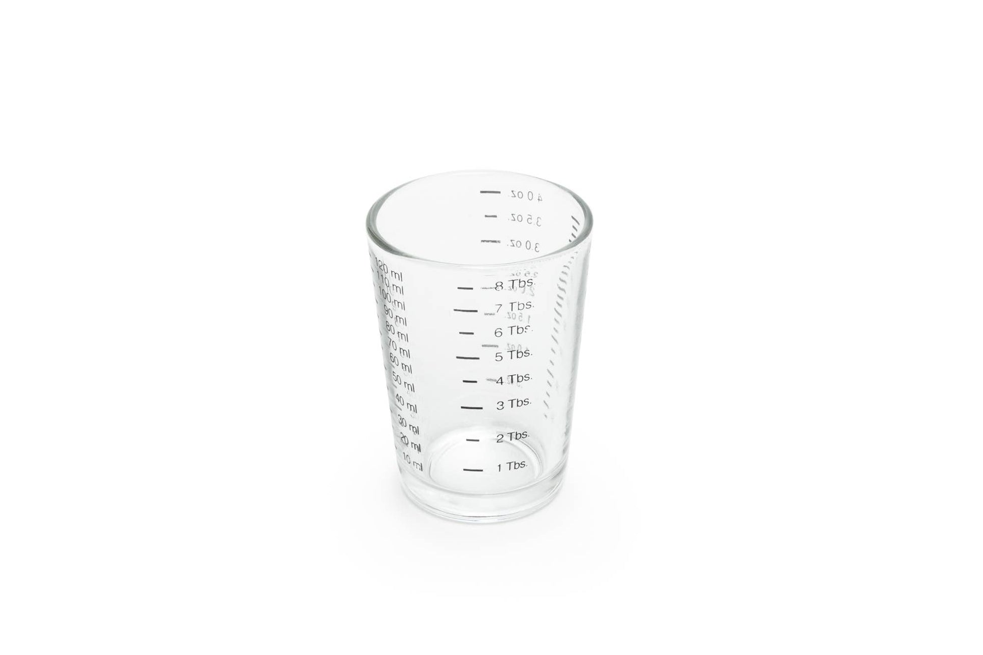 Clear glass measuring cup with black markings on a white background