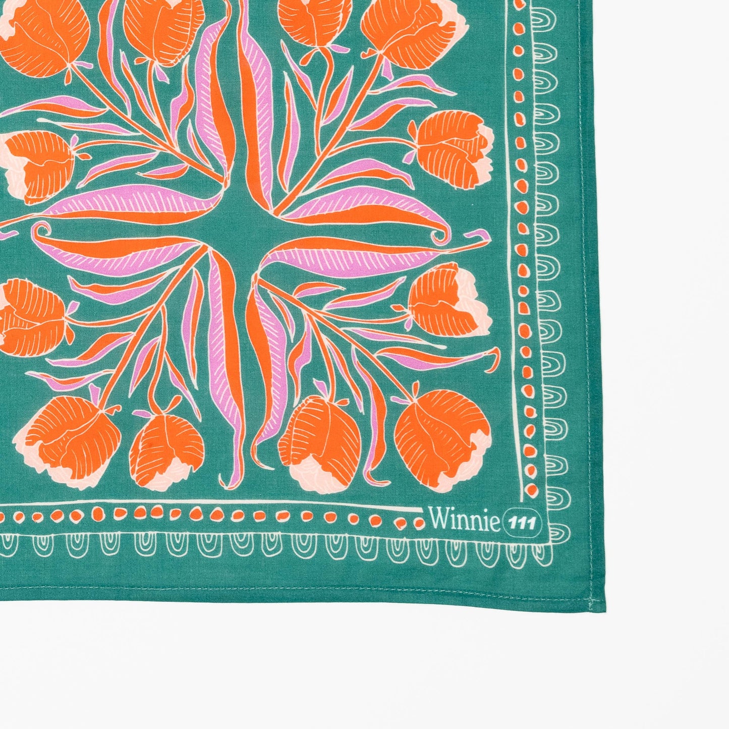 Floral patterned fabric with orange flowers and green background, featuring the brand 'Winnie 111'.