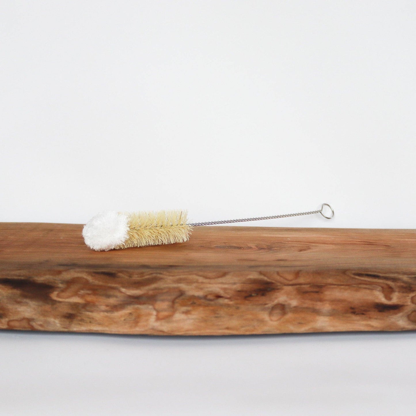 Wooden brush with bristles and a metal handle on a white background