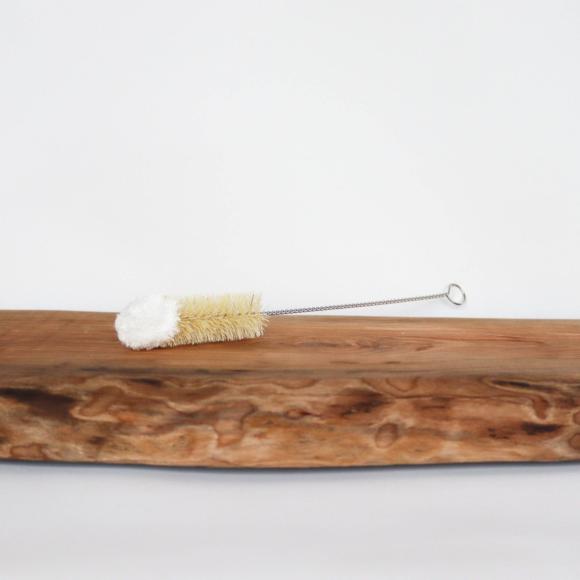 Wooden brush with bristles and a metal handle on a white background