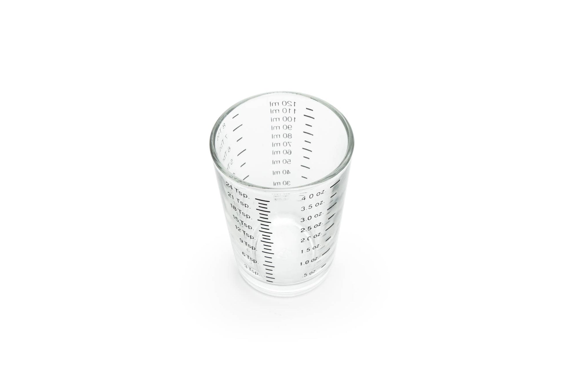 Clear glass measuring cup with measurement markings on a white background