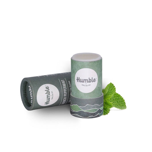 Two cylindrical lip balm containers with 'humble' branding on a white background.