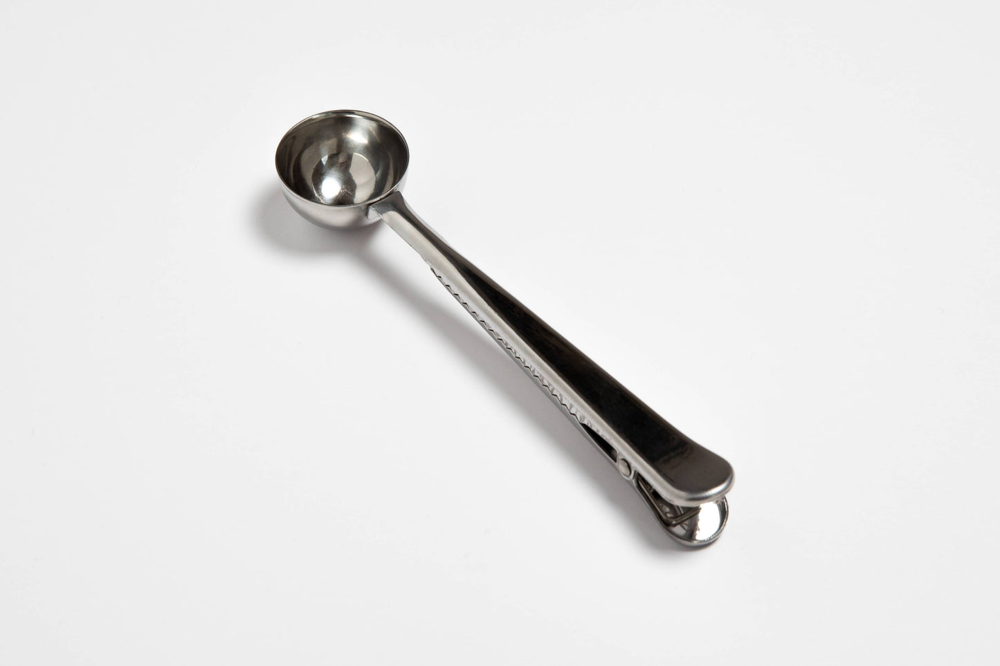 Metal measuring spoon on a white background