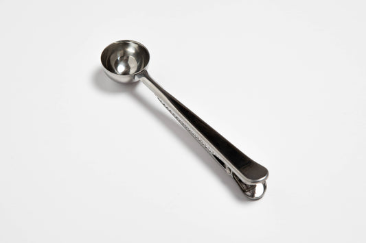 Metal measuring spoon on a white background