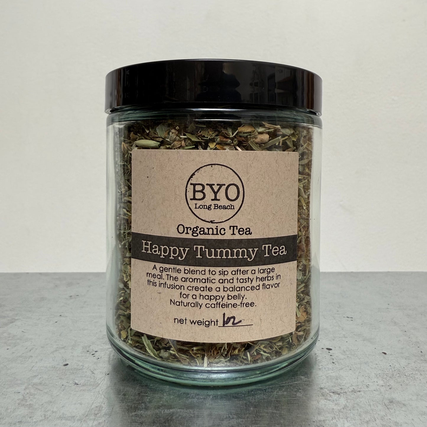Glass jar of organic tea with a label on a gray surface