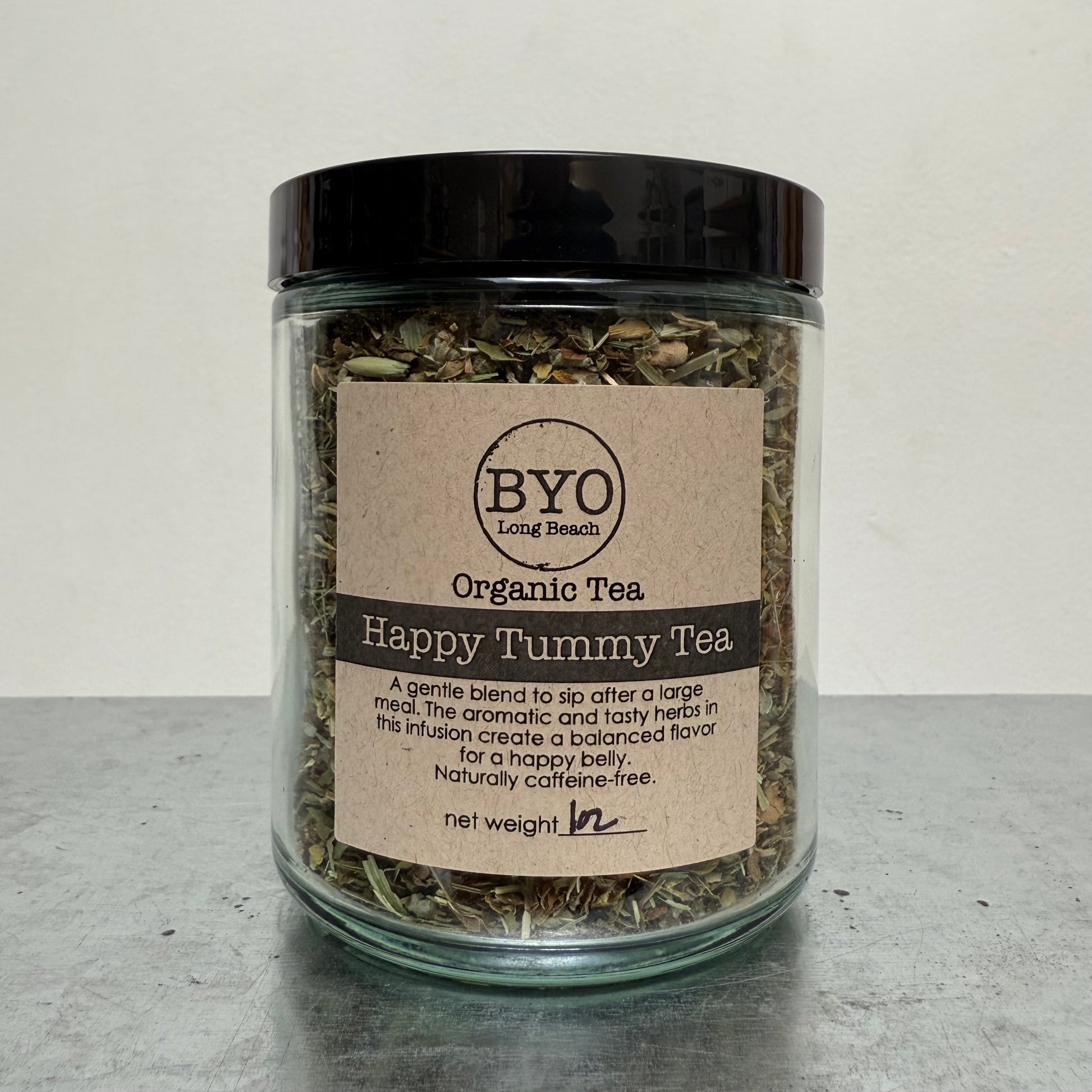 Glass jar of organic tea with a label on a gray surface