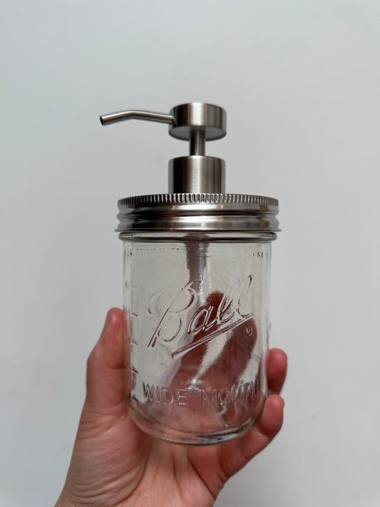 Hand holding pint mason jar with stainless steel wide mouth pump top