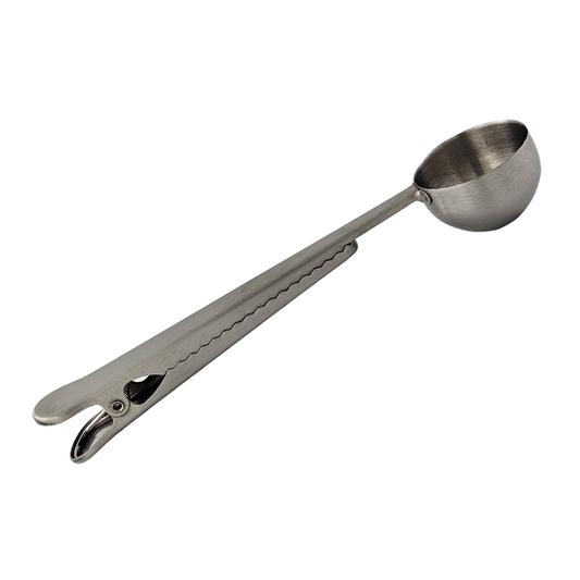 Metallic measuring scoop with a clip on a white background