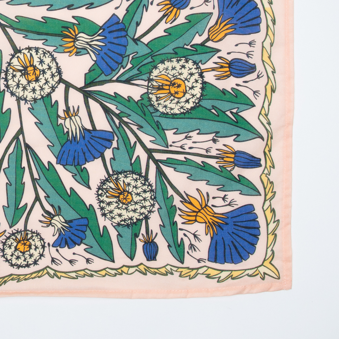 Floral patterned fabric with blue, green, and yellow flowers on a light pink background