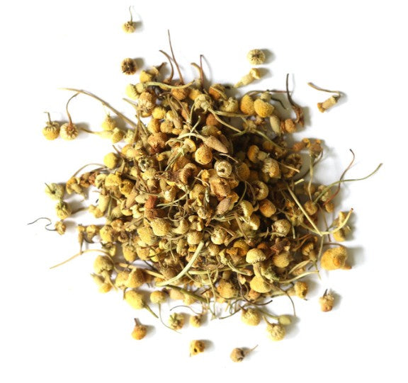 Pile of dried chamomile flowers on a white background