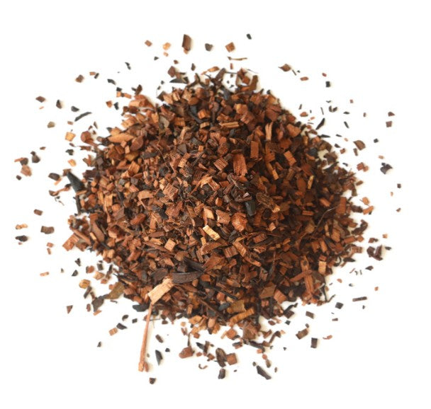 Heap of dried brown tea leaves on a white background