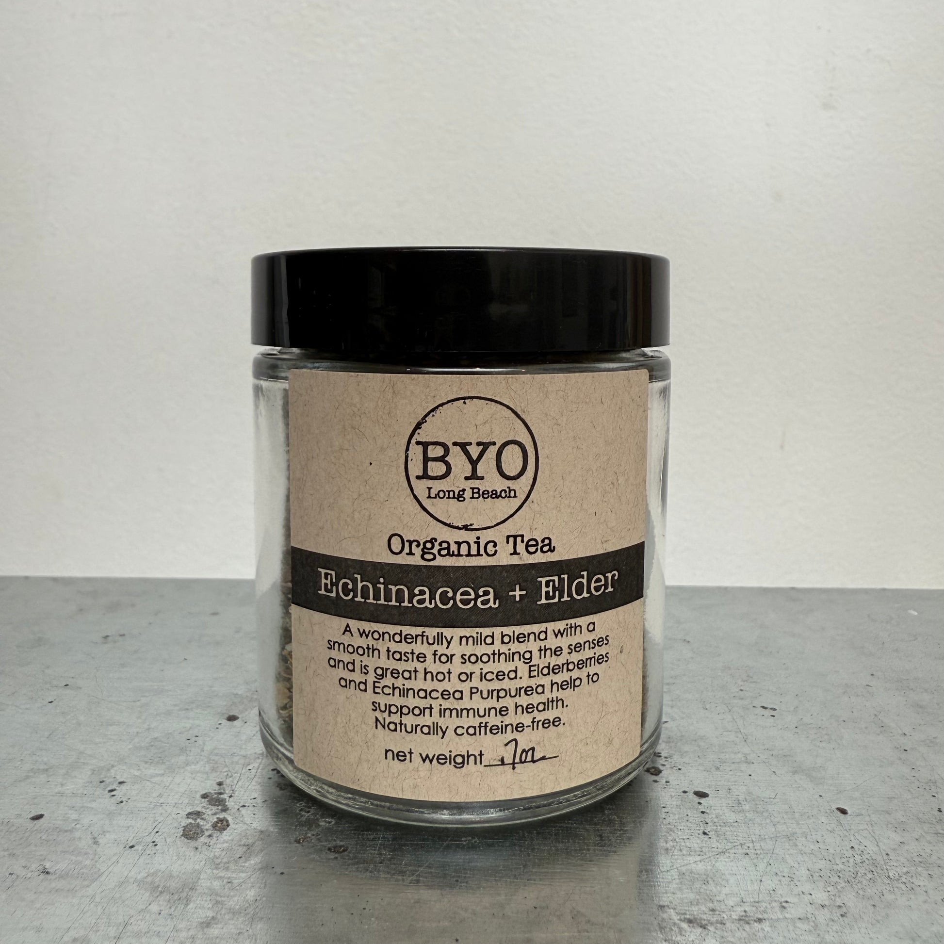 Glass jar of Organic Tea with 'BYO' label on a gray surface