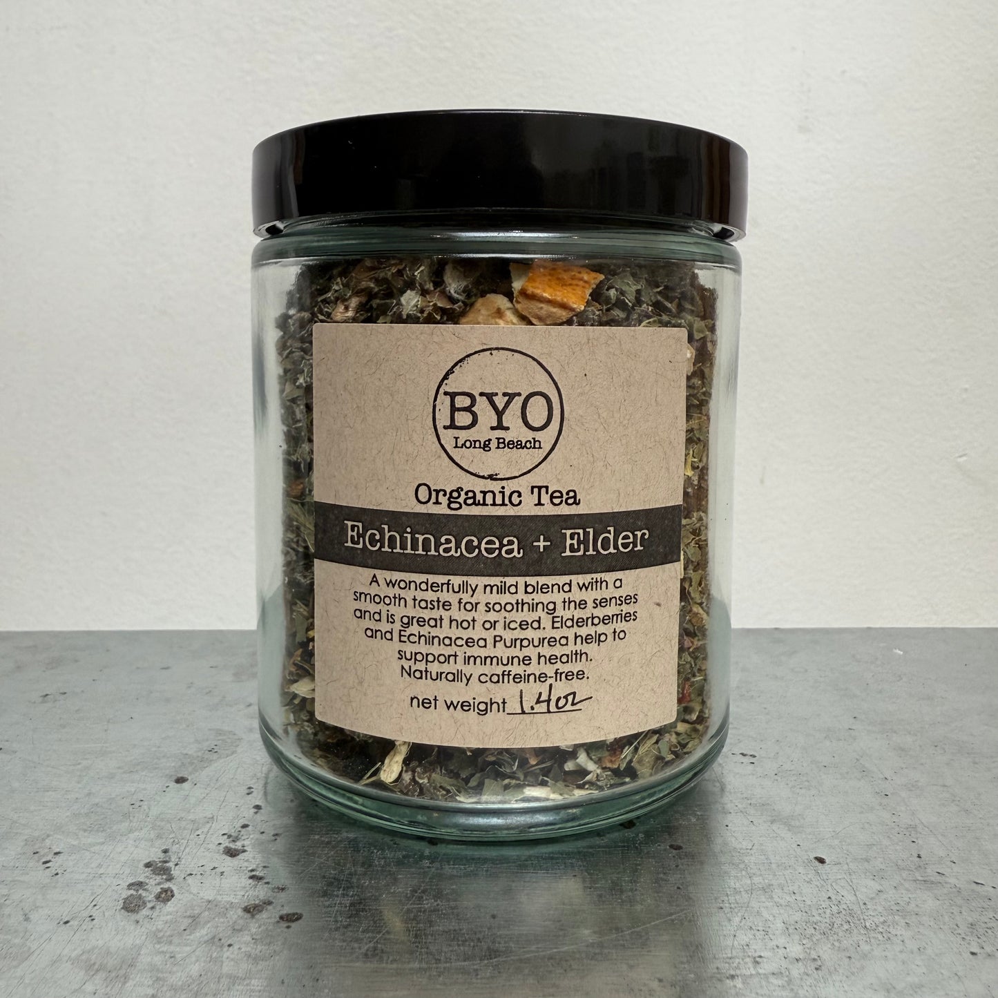 Glass jar of organic tea with a label on a gray surface