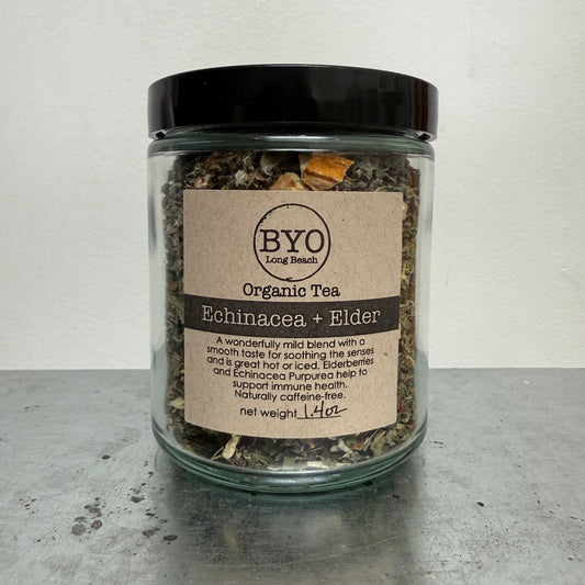 Glass jar of organic tea with a label on a gray surface