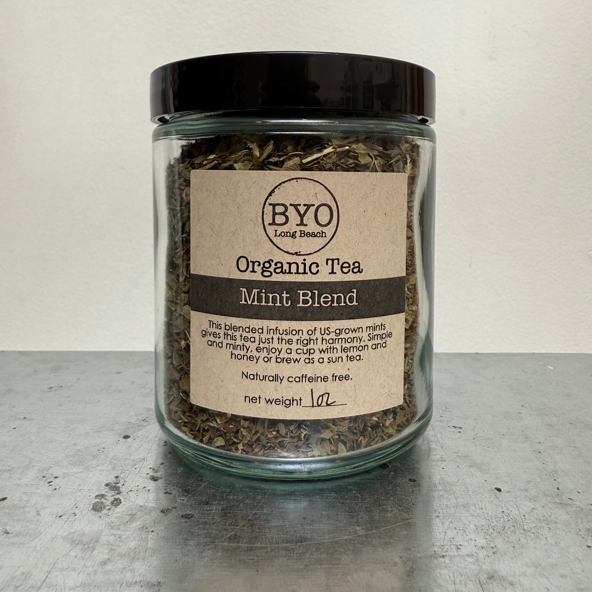 Glass jar of organic mint tea blend with a label on a gray surface