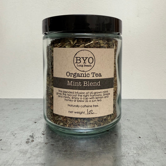 Glass jar of organic mint tea blend with a label on a gray surface