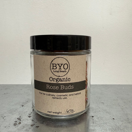 Jar of organic rose buds with a black lid on a gray surface