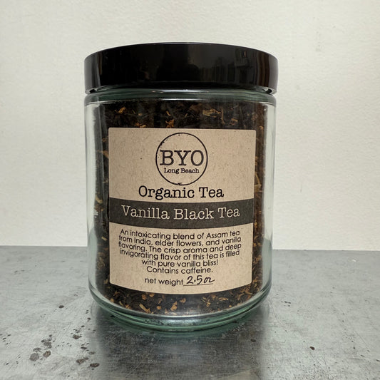 Jar of organic vanilla black tea with a label on a gray surface