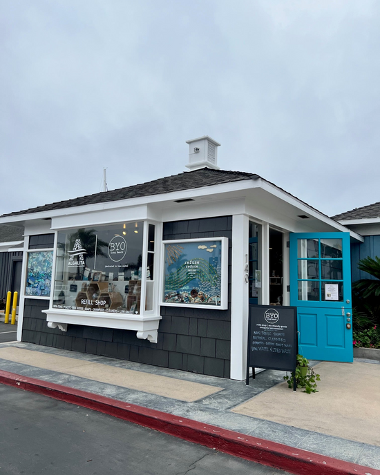 Storefront with a blue door and black exterior on a cloudy day