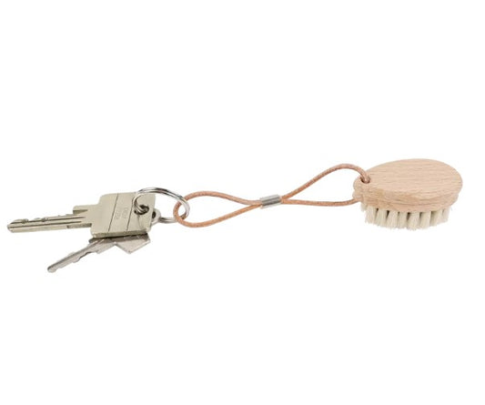 Small wood brush with natural bristles on a keychain with keys shown for scale.