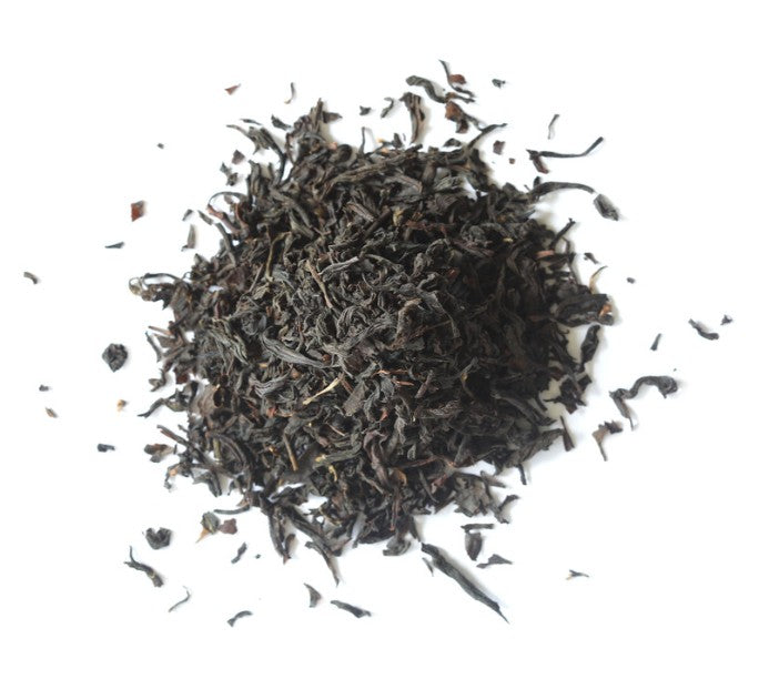 Dry black tea leaves on a white background
