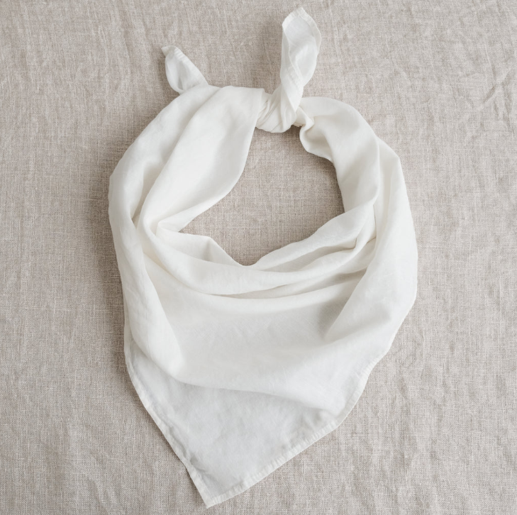 White scarf on a beige textured fabric background