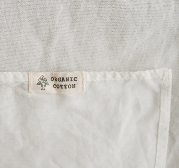 Close-up of a white fabric with an 'Organic Cotton' label.