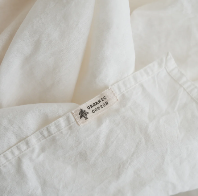 Close-up of a white garment with an 'Organic Cotton' label.