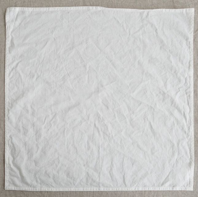 White textured fabric on a beige background