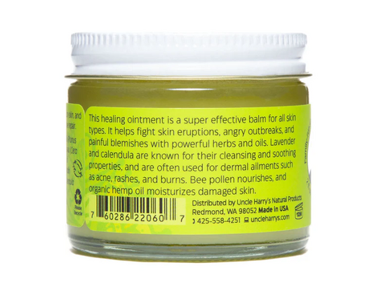Jar of healing ointment with green label and white lid on a white background