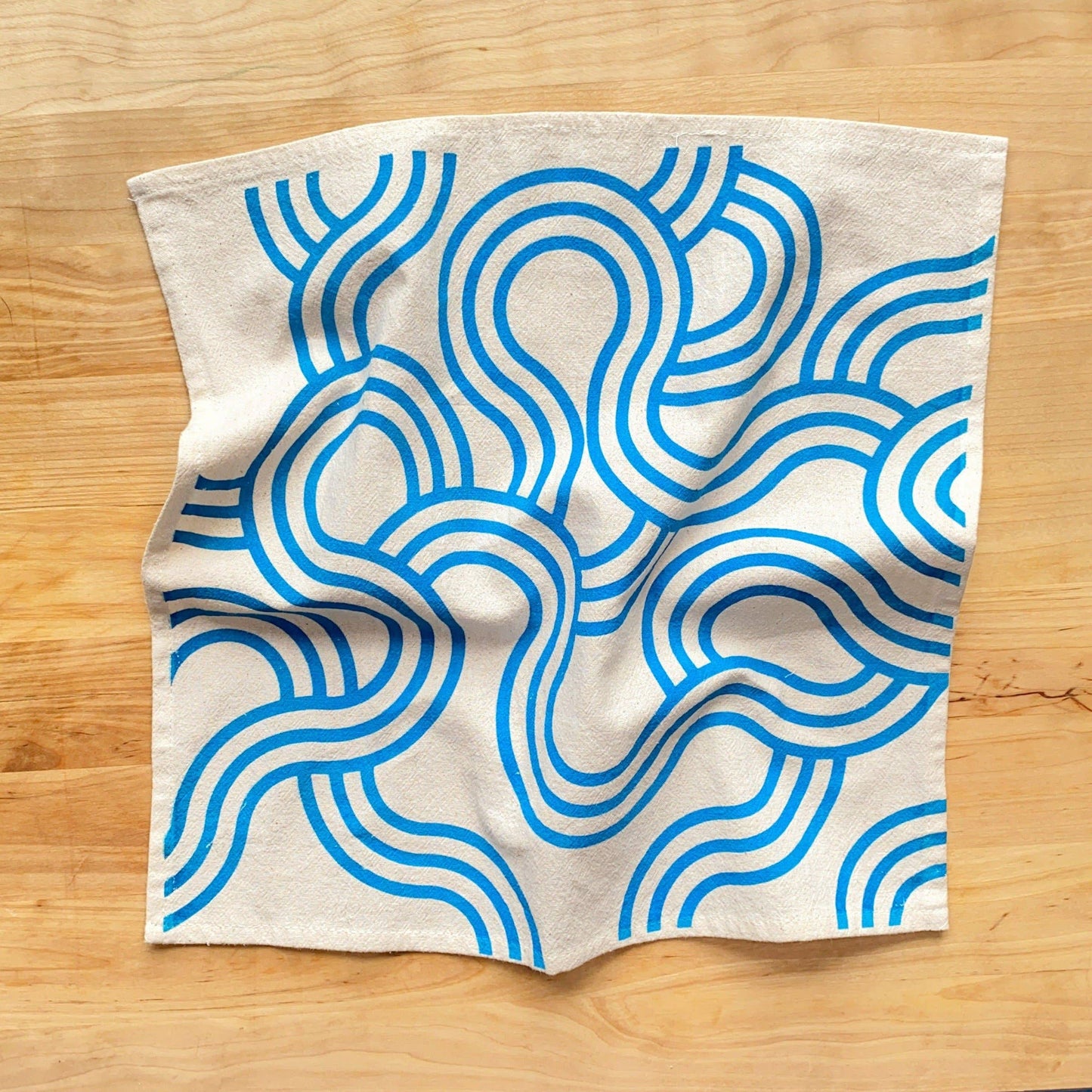 Fabric with blue wave pattern on a wooden surface